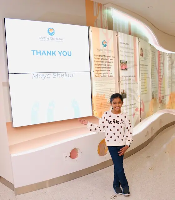 Maya beside the Seattle Children's donor thank-you screen showing her name